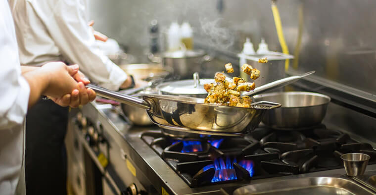 Chef tossing and cooking food in a pan