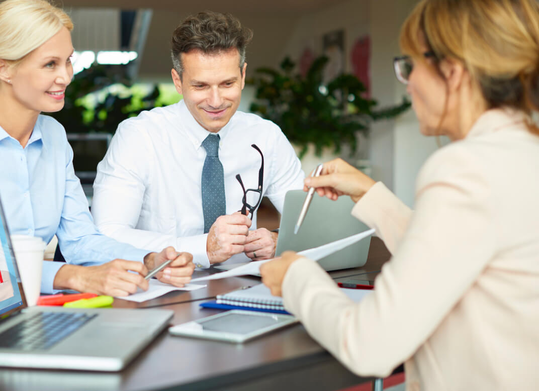 Woman consults with two customers on security solutions