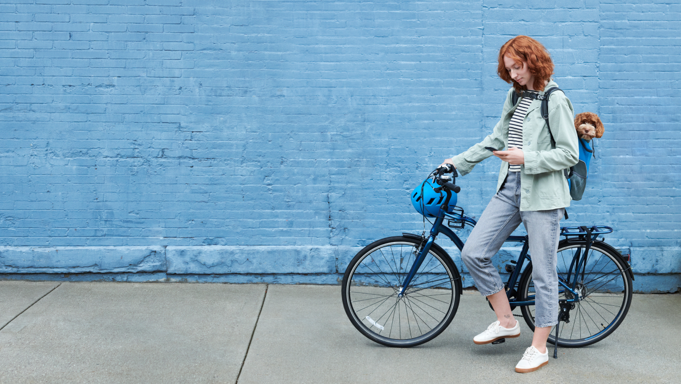 Women on a bike using the ADT+ app on her phone