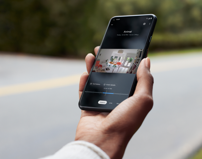 Hand holding a cell phone showing footage from his Google Nest Cam