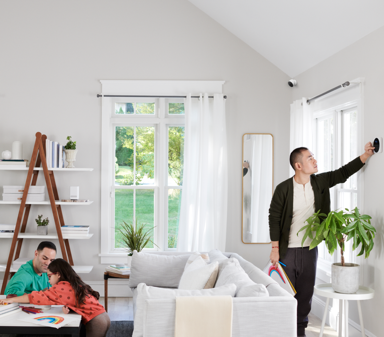 Google Nest Cam installed in a living room where a family is coloring together 