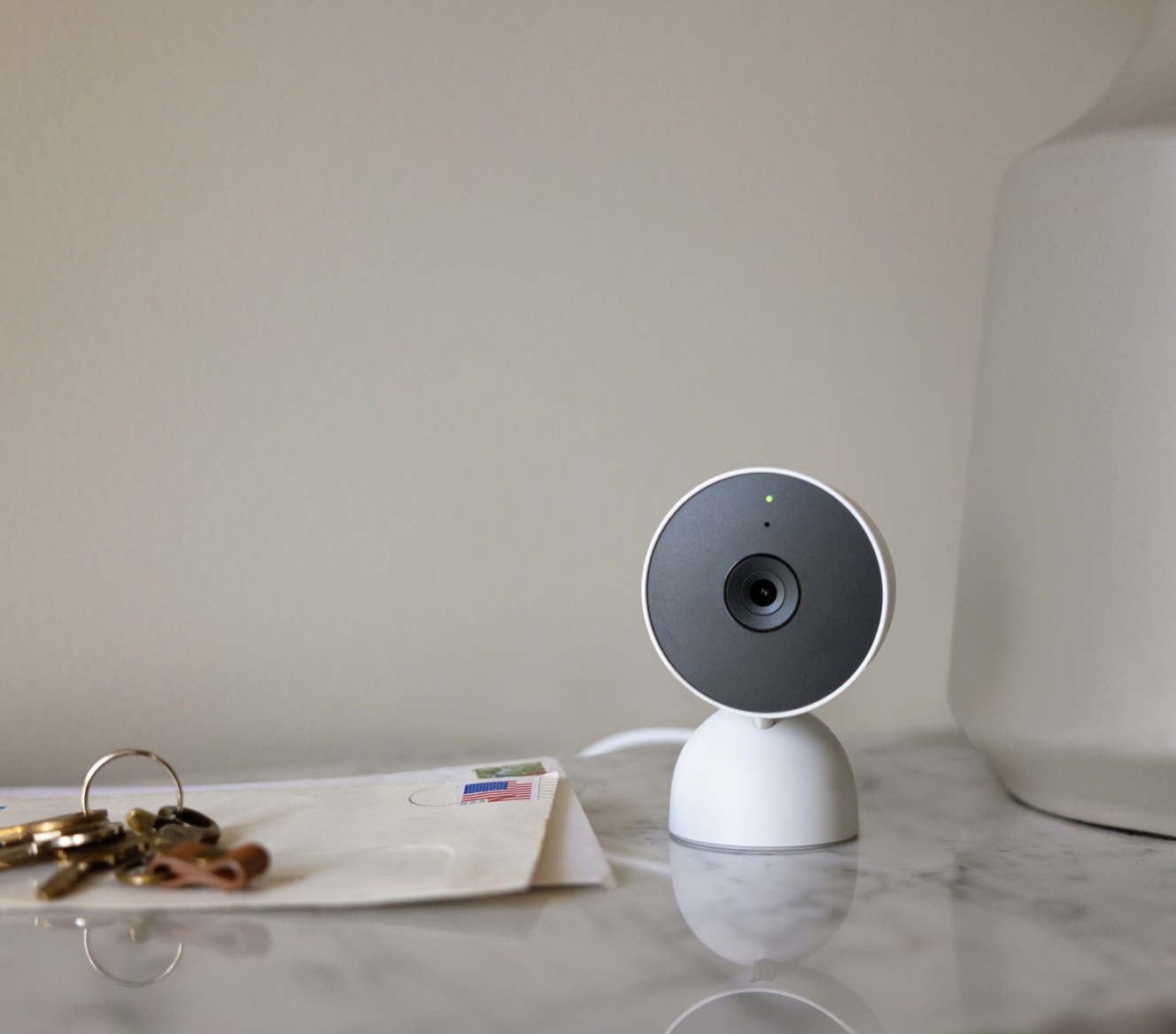 Google Nest Cam (Indoor) on a table next to house keys and mail