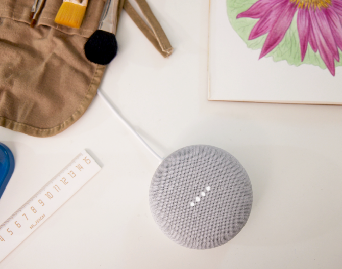 Google Nest Mini on a table with paint brushes and a ruler